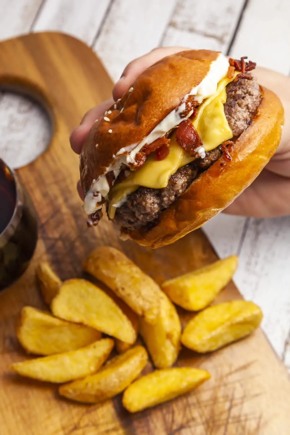 Hambúrguer da Convicta com queijo e bacon, acompanhado de batatas rústicas